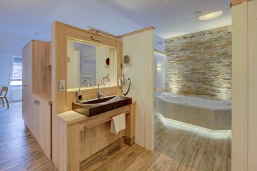 a bathroom with a sink and a bath tub at Hotel Erve Hulsbeek in Oldenzaal