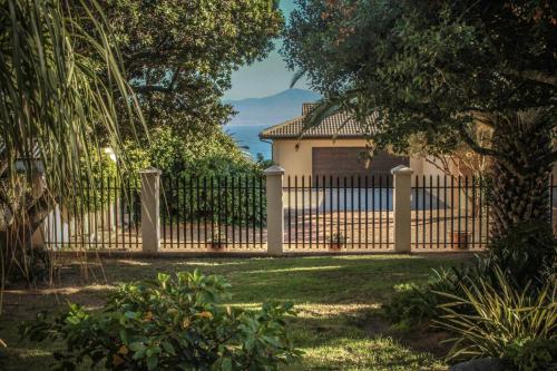 a fence in front of a house at C-Vu-Cottage cosy and warm private apartment in Mossel Bay