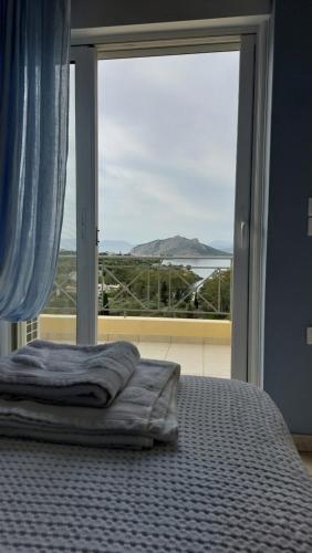 a bed in a bedroom with a large window at new serenity villa aegina in Aegina Town