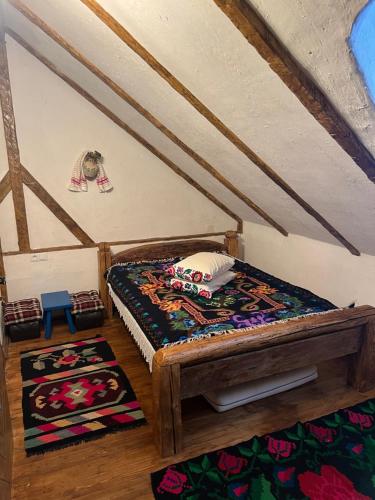 Cette petite chambre comprend un lit et un tapis. dans l'établissement Casa Colț din Maramureș - Old Traditional House, à Ocna Şugatag