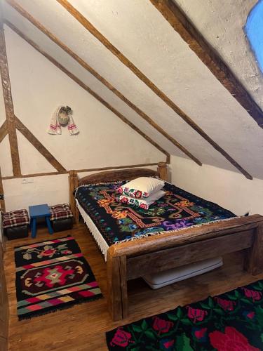 a small room with a bed and a rug at Casa Colț din Maramureș - Old Traditional House in Ocna Şugatag
