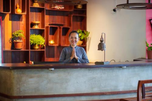 a man is sitting at a bar with his hands in prayer at SAKABAN Suite in Siem Reap