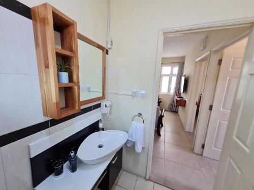 La salle de bains est pourvue d'un lavabo et d'un miroir. dans l'établissement Le Mirage Exotique, à Flic-en-Flac