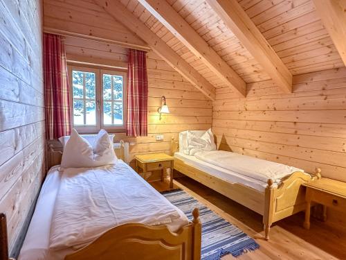 a room with two beds in a log cabin at 1A Chalet Koralpenzauber - Wandern, Sauna, Grillen mit Traumblick in Wolfsberg