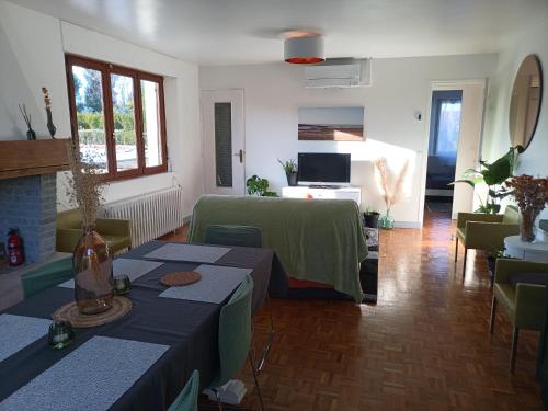 een woonkamer met 2 tafels en een bank bij la coccinelle in Conflans-Sainte-Honorine