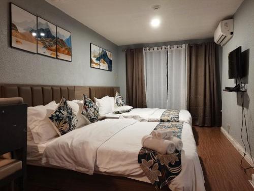 een hotelkamer met 2 bedden en een teddybeer op het bed bij TemporaryHome -susan in Manilla