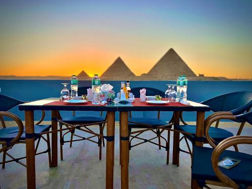 Pyramids Hotel في القاهرة: طاولة عليها كراسي وزجاجات ماء فوق الهرم