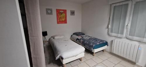 une petite chambre avec deux lits et une fenêtre dans l'établissement 15 minutes du centre-ville, à Troyes
