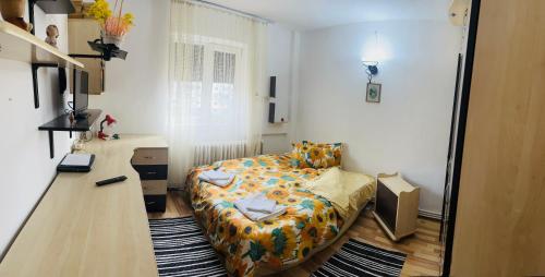 a small bedroom with a bed and a desk at Apartament Cornelia in Buzău
