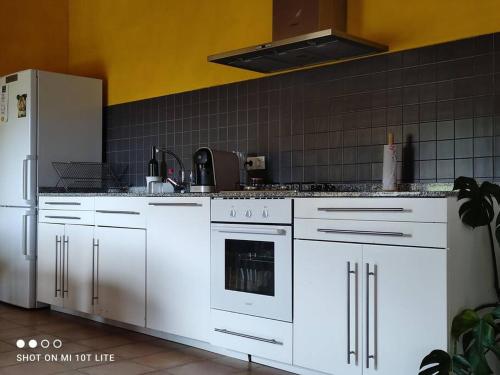 cocina con armarios blancos y nevera blanca en Apartamento rural con entrada independiente, en Múgica
