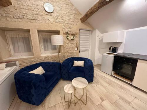 a living room with a blue couch and two chairs at Maisonnette spa privée - terrasse commune in Talant