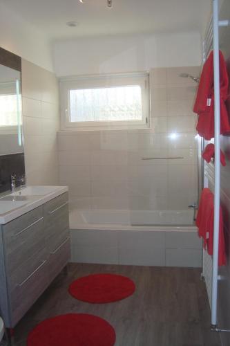 une salle de bain avec une baignoire, un lavabo et une fenêtre dans l'établissement Maison proche du centre de Colmar - Chez Michel, à Horbourg-Wihr