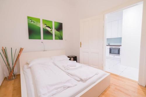 um quarto branco com uma cama branca e uma cozinha em Vienna Residence, Gumpendorfer Straße - Mariahilf #527 em Viena