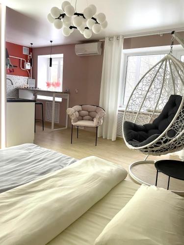 1 dormitorio con cama y silla colgante en Квартира Тропики центр міста st Remisnycha 55a, en Cherníhiv