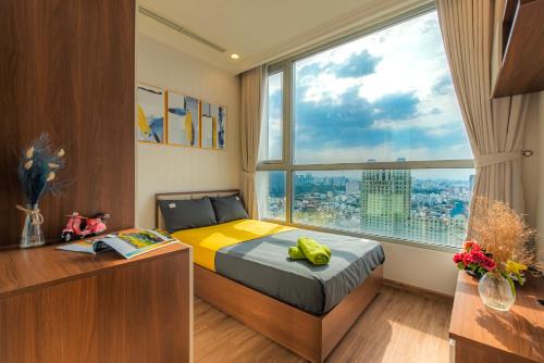 a bedroom with a bed and a large window at Raddison Luxury Apart - Vinhome Central Park, Landmark 81 Area and Great Park in Ho Chi Minh City
