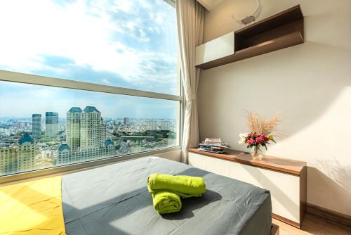 a bedroom with a large window and a bed with a green pillow at Raddison Luxury Apart - Vinhome Central Park, Landmark 81 Area and Great Park in Ho Chi Minh City