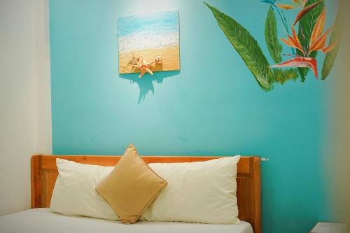 a blue wall with a picture of a woman on the beach at Sông Suối Homestay in Quy Nhon