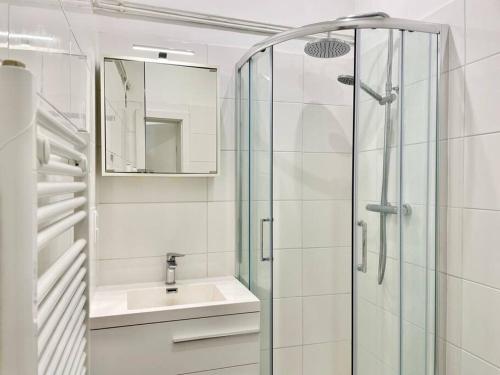 a white bathroom with a sink and a shower at 55m2 Stylish Apartment with Netflix - 15 min to Center in Vienna