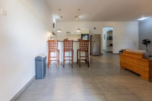a living room with chairs and a kitchen with a counter at Cocobana Resort two-bedroom apartment ground floor in Willemstad