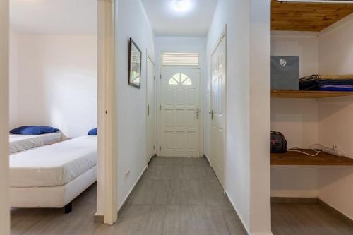 a small bedroom with a bed and a closet at Cocobana Resort two-bedroom apartment ground floor in Willemstad
