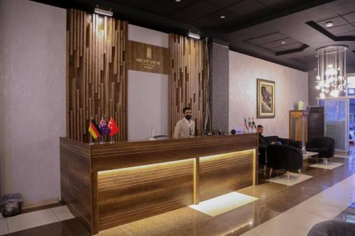 a man standing behind a reception desk in a salon at Nightview Erbil in Erbil