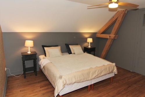 um quarto com uma cama e duas mesas de cabeceira com candeeiros em Location de Prestige : Duplex au Caractère Unique et Raffiné em Villefranche-sur-Saône
