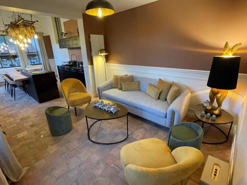 uma sala de estar com um sofá e cadeiras em La Petite Maison de Giverny - Gîte de charme 5 étoiles au cœur du village - 3 Chambres em Giverny