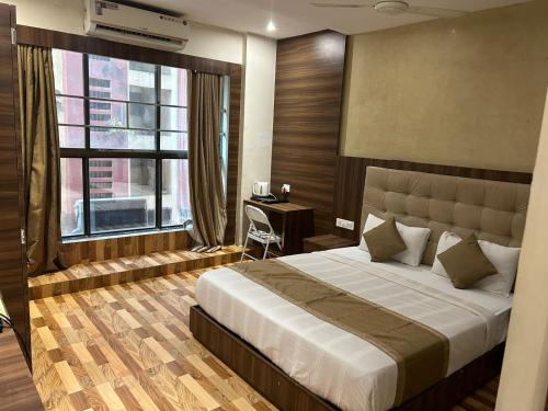 ムンバイにあるHotel BKC Mannatのベッドルーム1室(ベッド1台、デスク、窓付)