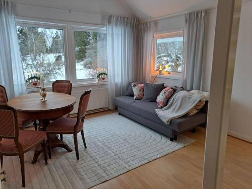 ein Wohnzimmer mit einem Sofa und einem Tisch in der Unterkunft Litet strandnära hus på Adelsö in Adelsö