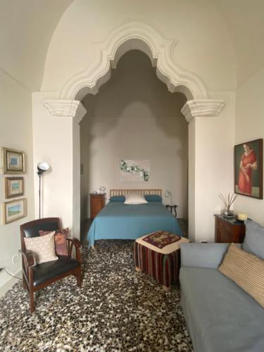 Un dormitorio con una cama, una silla y un sofá. en Casa VicoloLungo Nardó, en Nardò