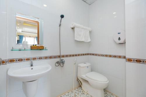ein weißes Bad mit einem WC und einem Waschbecken in der Unterkunft Diamond Star Hotel in Vũng Tàu