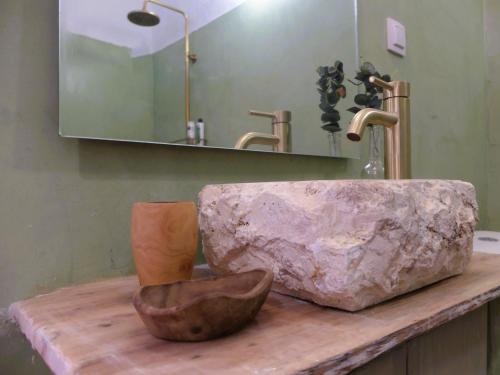 a bathroom with a stone sink and a mirror at Kavousi Cottages - H Petra in Kavoúsion