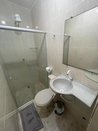 La salle de bains est pourvue d'une douche, de toilettes et d'un lavabo. dans l'établissement Apartamento a 1 km da Orla de Atalaia, à Aracaju