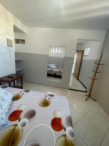 Cette chambre dispose d'une table avec des bols de couleur différente sur le sol. dans l'établissement Apartamento a 1 km da Orla de Atalaia, à Aracaju