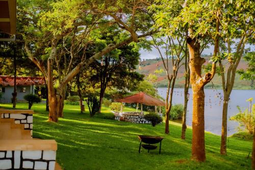 a park with a picnic table next to a lake at Gihanga Resort 