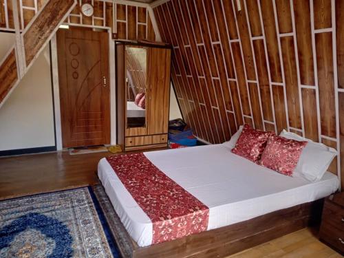 a bedroom with a bed with red pillows on it at Orchard Farmstay in Bijanbāri Bāzār