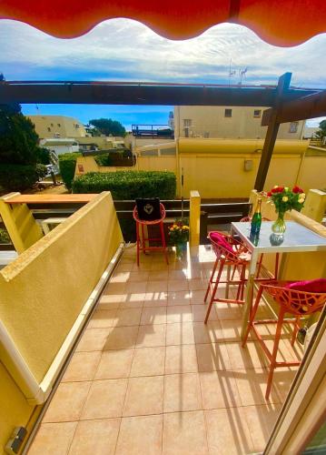 un balcon avec une table et des chaises sur un balcon dans l'établissement Naturiste Cap d'Agde Port Nature 312, au Cap d'Agde