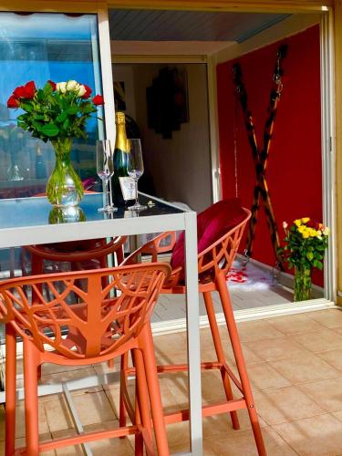 une table à manger avec deux chaises et un vase de fleurs dans l'établissement Naturiste Cap d'Agde Port Nature 312, au Cap d'Agde
