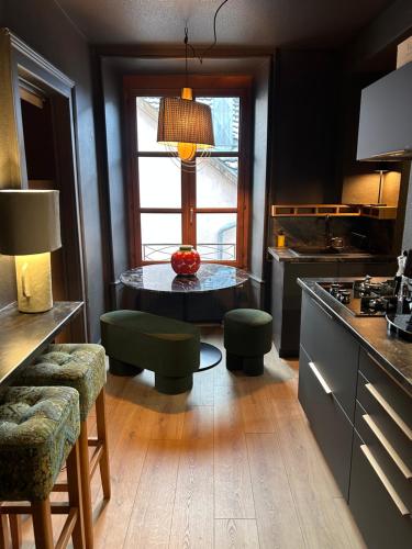 une cuisine avec une table et des chaises et une fenêtre dans l'établissement Palmaria, à Montbéliard