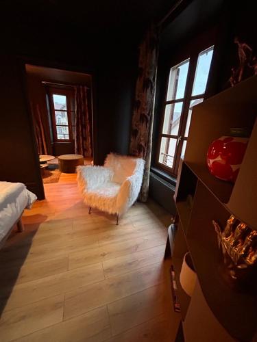 - un salon avec une chaise blanche et des fenêtres dans l'établissement Palmaria, à Montbéliard