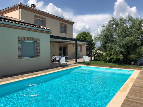 a swimming pool in front of a house at Le Réal in Roquemaure