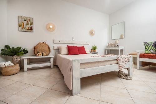 a bedroom with a bed with red pillows on it at Aggeliki's Diamond in Agia Anna Naxos
