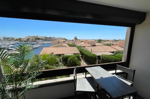 d'un balcon avec une table et une vue sur le port. dans l'établissement Naturiste Cap d'Agde Port Vénus 206, au Cap d'Agde
