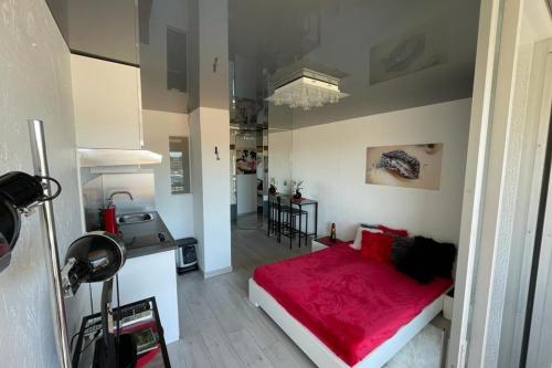 Cet appartement comprend une chambre avec un lit rouge et une cuisine. dans l'établissement Naturiste Cap d'Agde Port Vénus 206, au Cap d'Agde