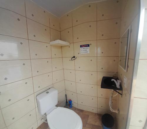 uma pequena casa de banho com WC e telefone em Chácara Recanto da Paz em Igaratá
