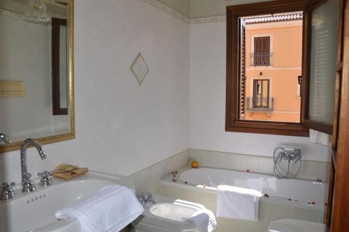 a bathroom with a tub and a toilet and a sink at Appartamento centrale elegante in Olbia