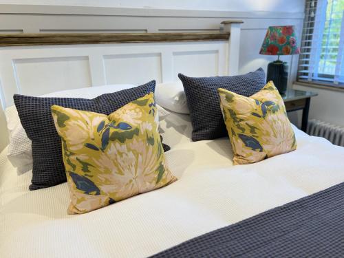 a bed with yellow and blue pillows on it at Nine Cooper Lane, Holmfirth in Holmfirth