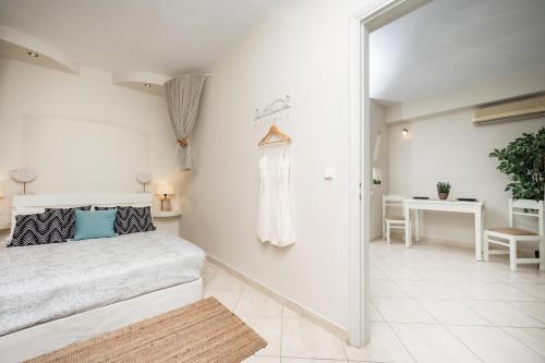 a white bedroom with a bed and a table at Aggeliki's Diamond in Agia Anna Naxos