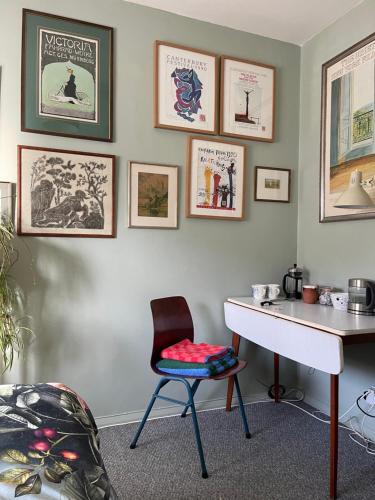 un bureau et une chaise dans une pièce avec des affiches murales dans l'établissement 4 Birkbeck Road Beckenham BR3 4SN, à Elmers End