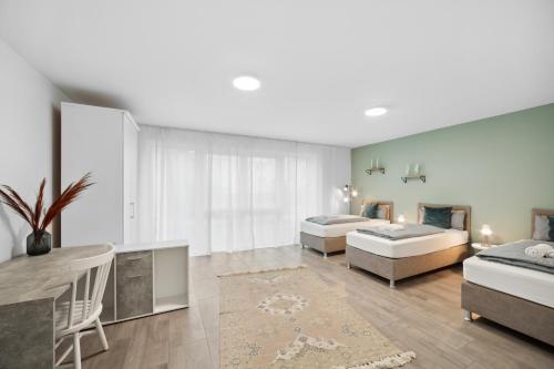 una camera con due letti, un tavolo e un divano di Sali Homes AM14 großes Apartment mit Terrasse im Zentrum a Bayreuth